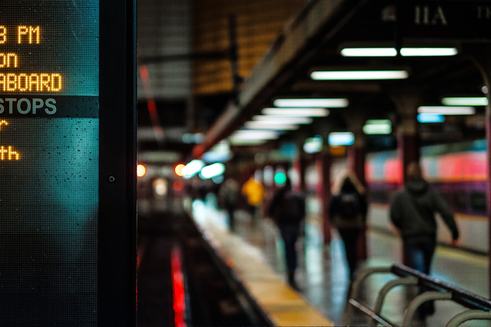 市営地下鉄のプラットホームに照らされた看板と、目的地まで歩く通勤客