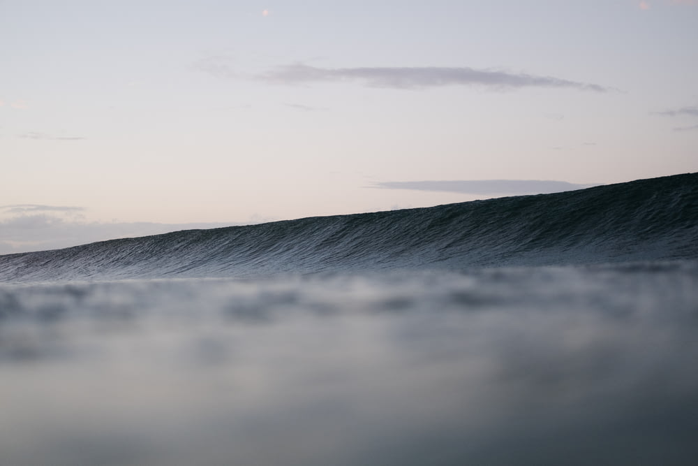 time lapsed photography of ocean wave under clear sky