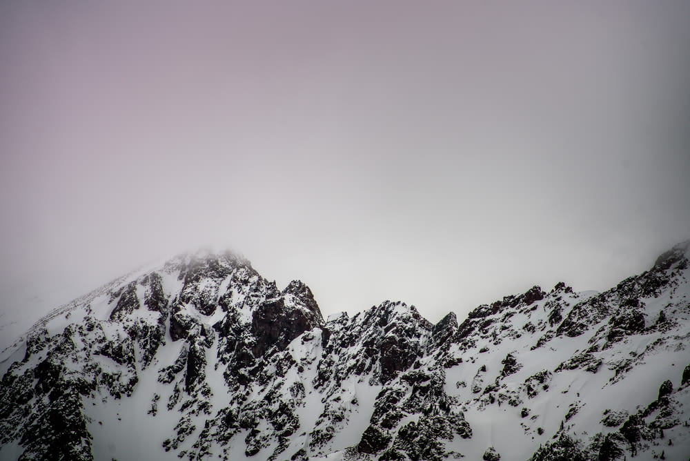 snow covered mountain under gray cloudy sky