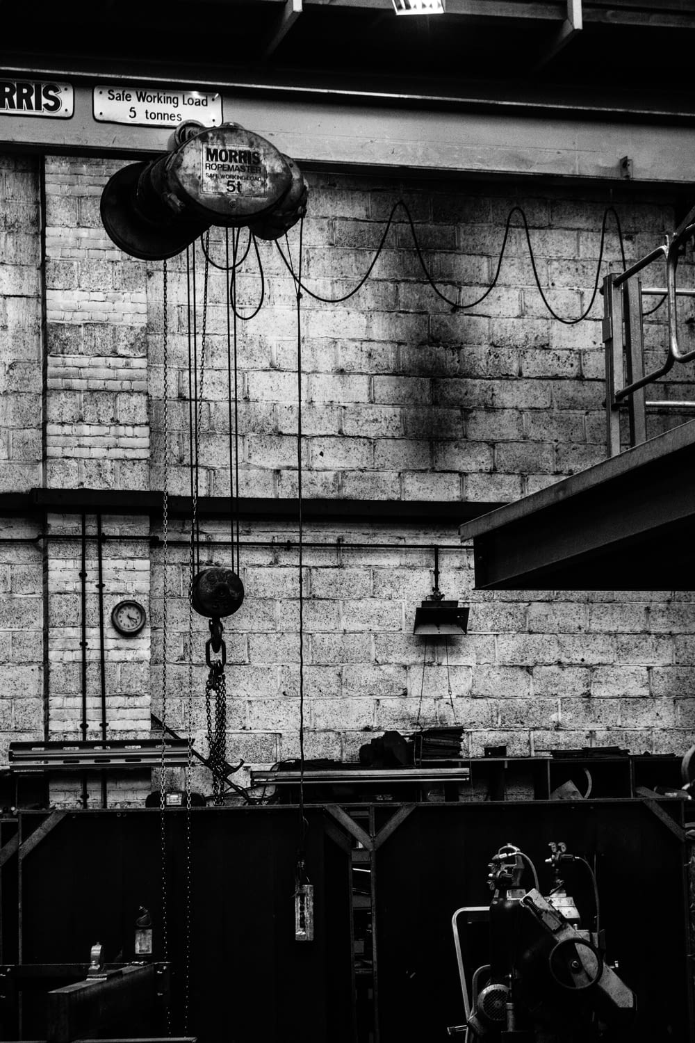 grayscale photography of wall with ropes and machine