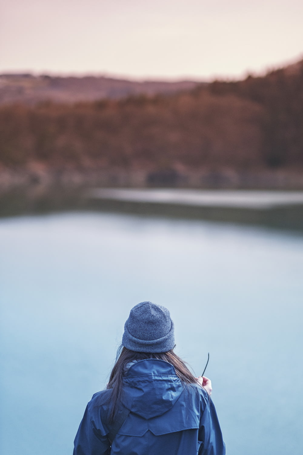 woman standing in front of lake selective focus photo