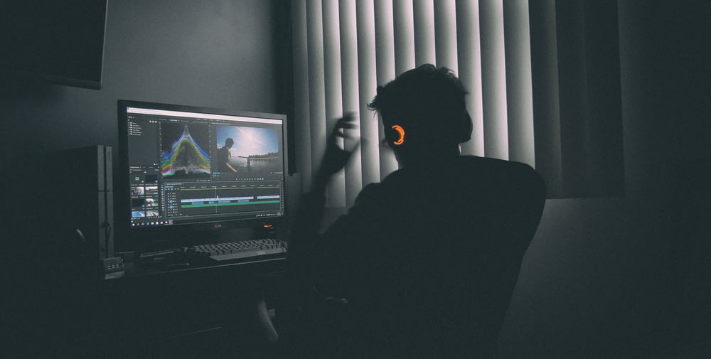 Flache Fokusfotografie eines Mannes, der vor dem Computer Musik auflistet