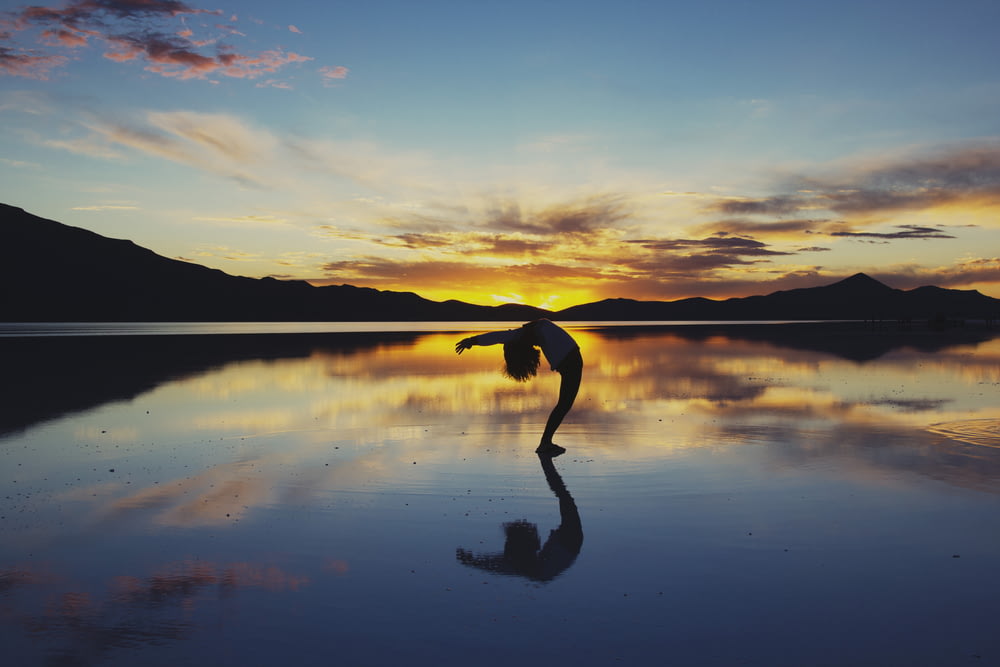 Fotografía de silueta de mujer haciendo yoga