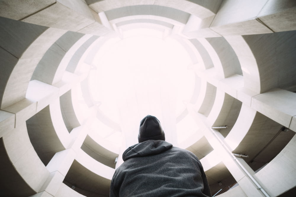 photography of person wearing gray hooded jacket inside building during daytime