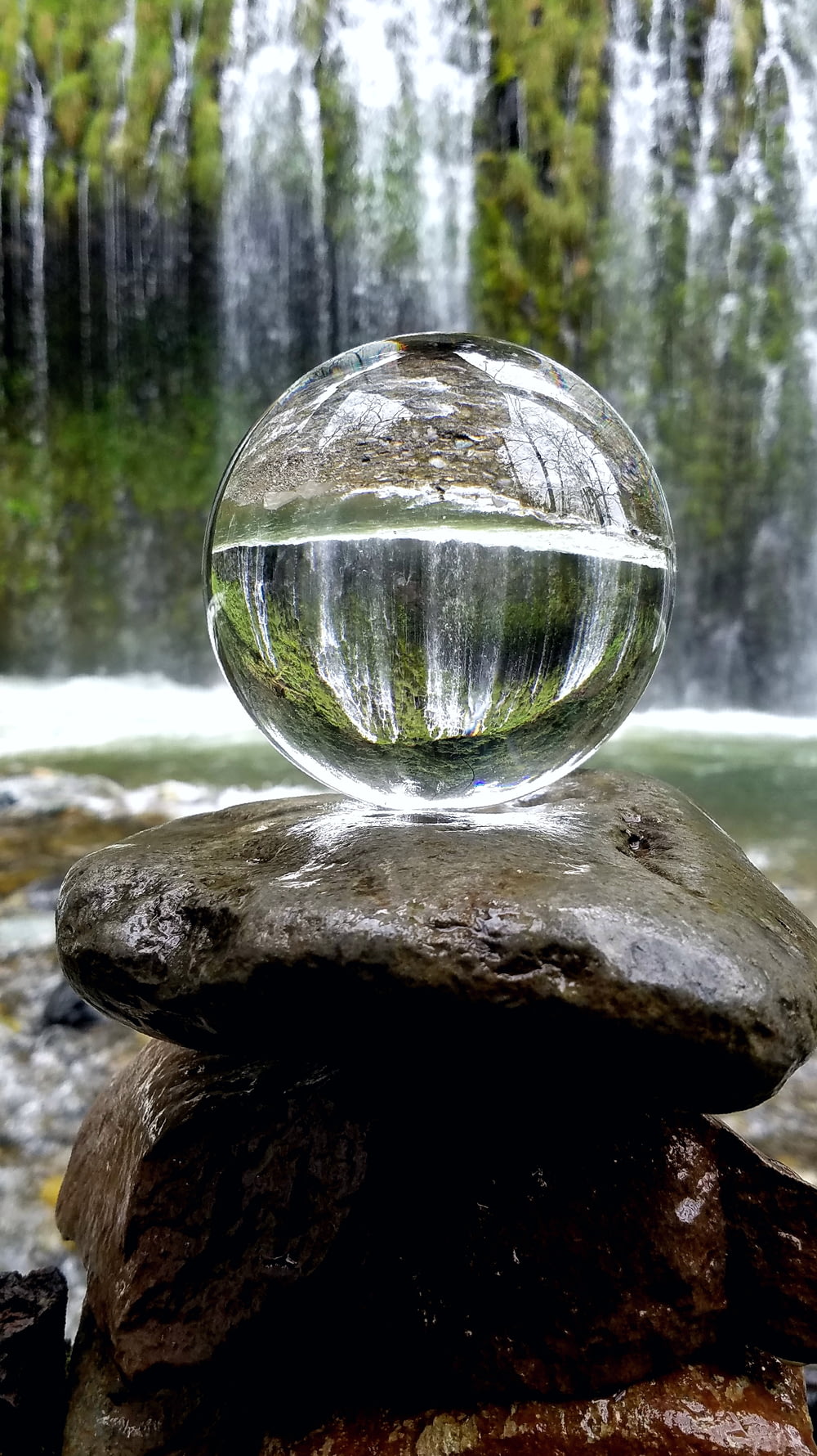 bola de vidrio transparente sobre roca marrón