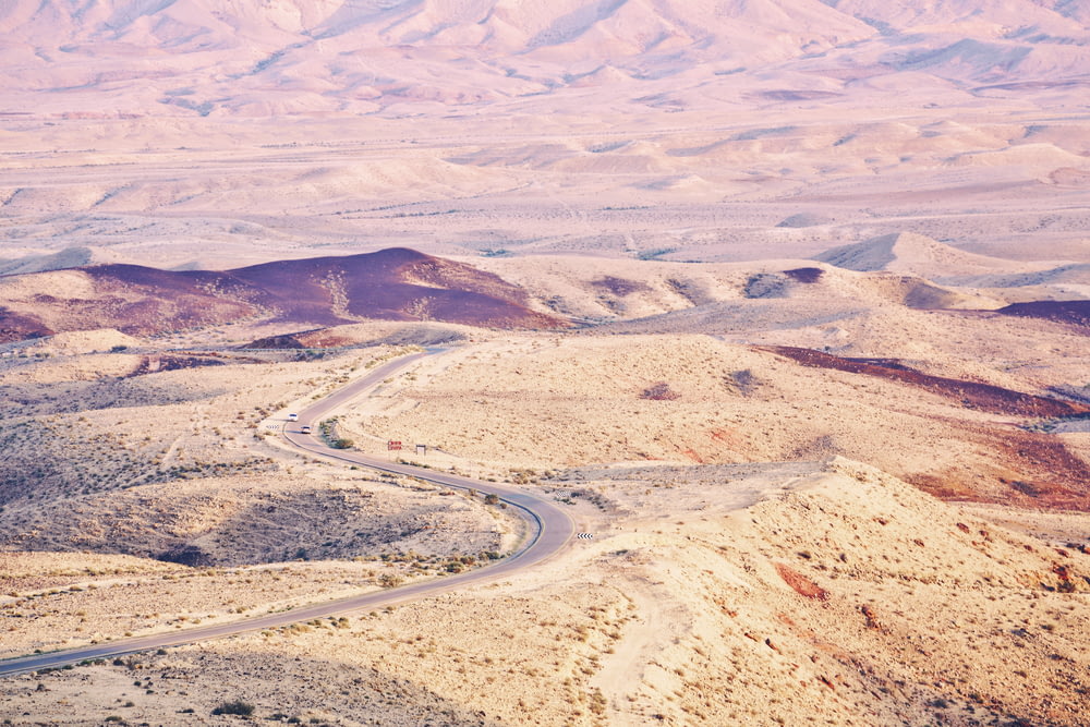 aerial photography of road between desert at daytime