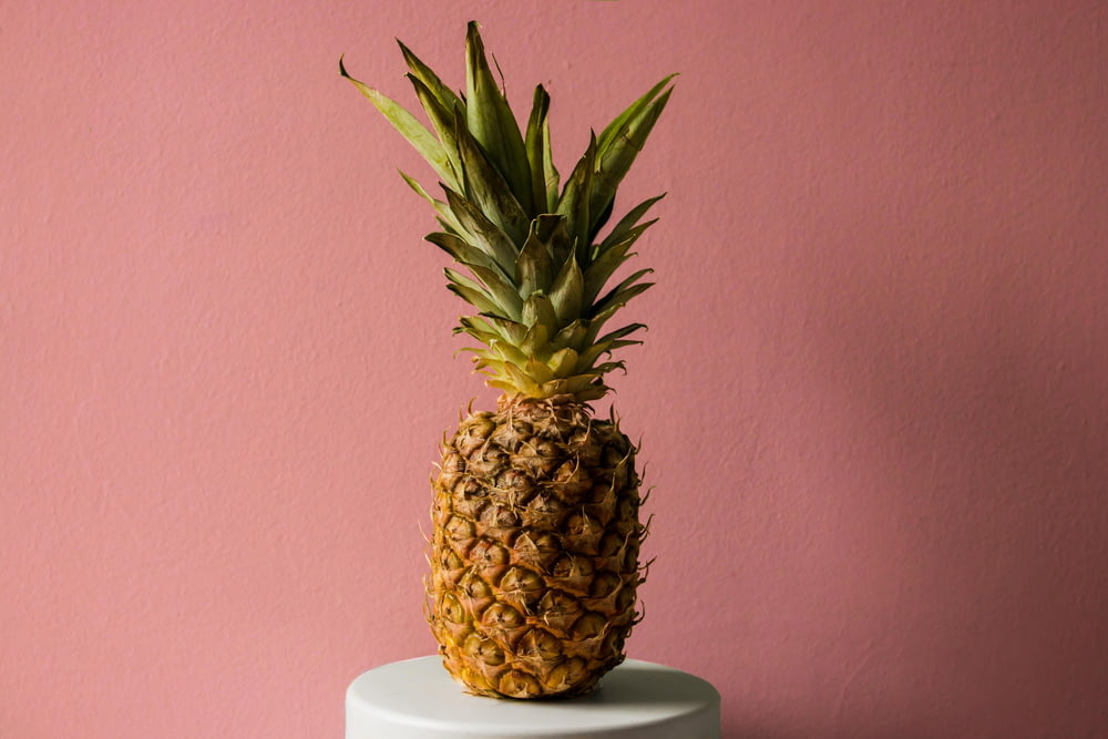 a pineapple sitting on top of a white cake