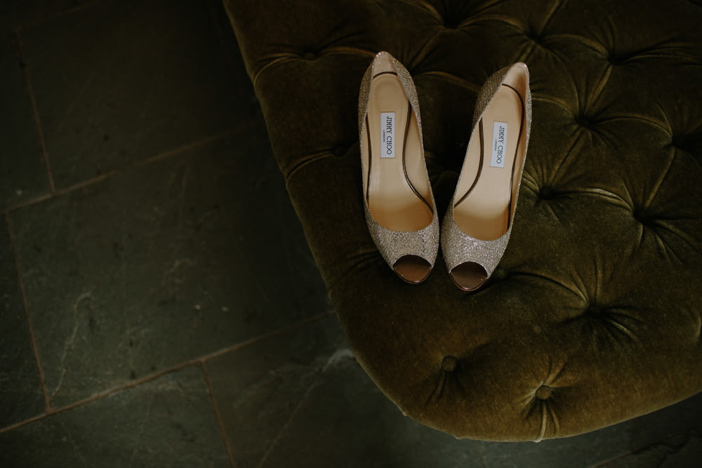 pair of brown gray leather open-toe heeled shoes on tufted mattress