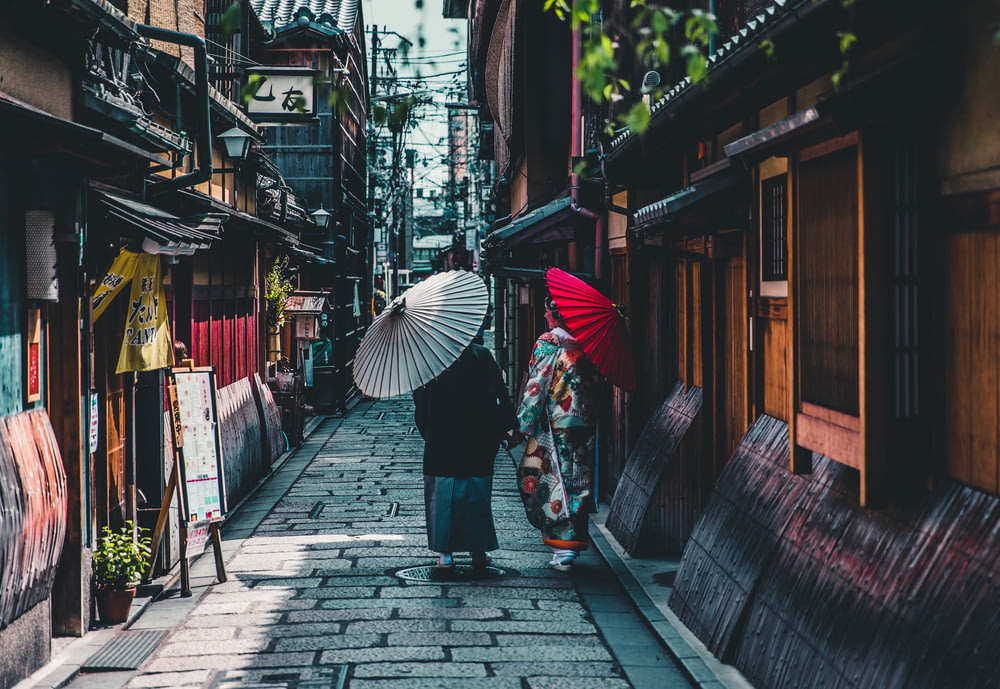 persona que camina por la calle mientras sostiene un paraguas