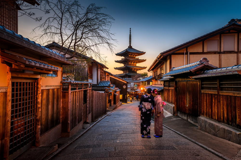 deux femmes en kimono violet et rose debout dans la rue