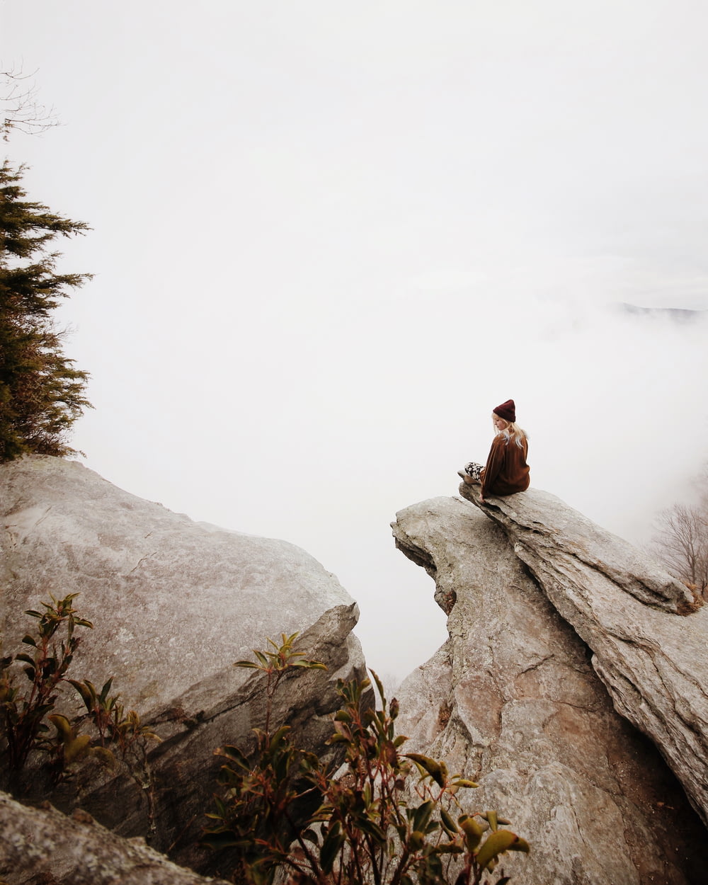 woman sitting on brown rock