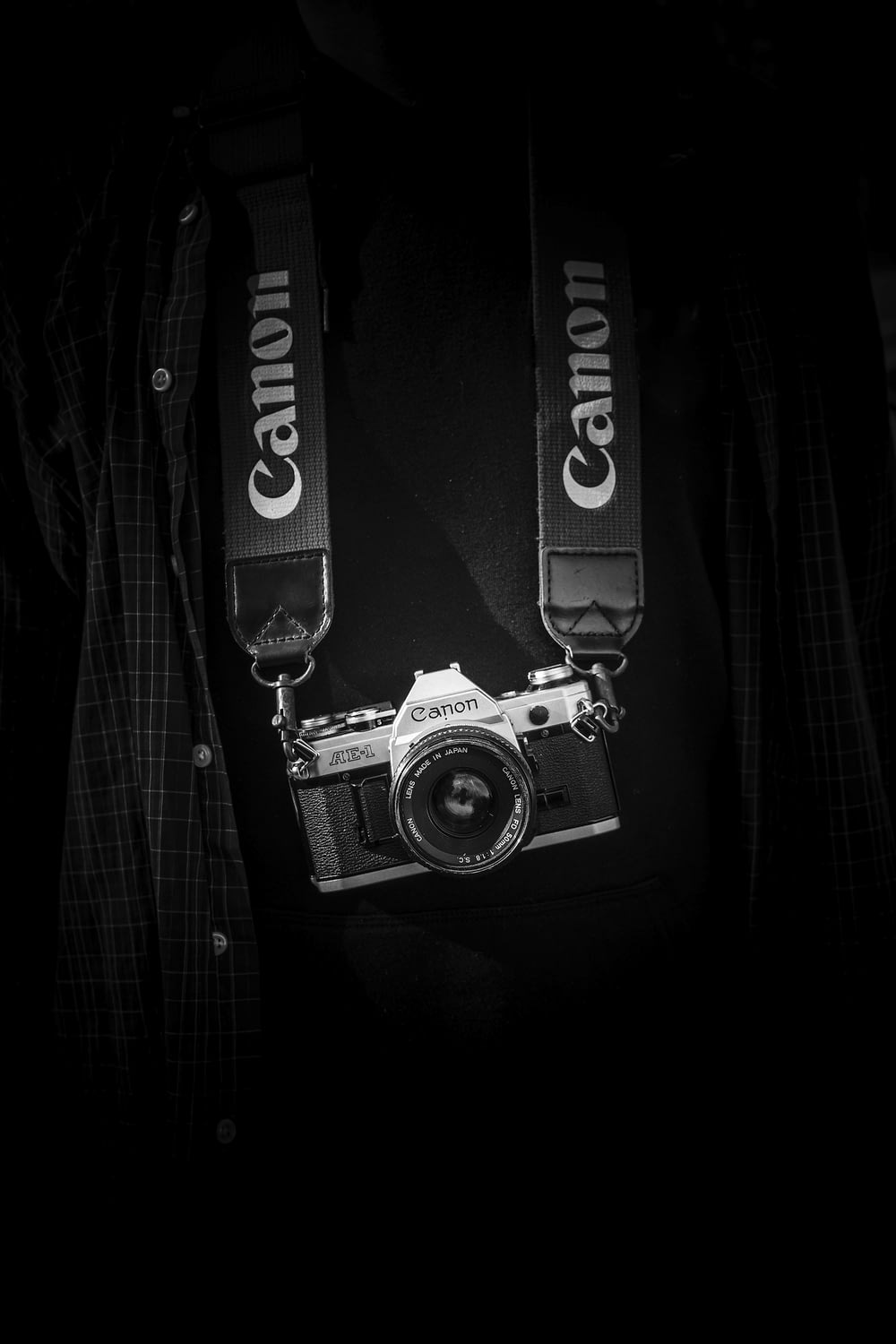 끈이 있는 회색과 검은색 Canon 카메라 본체
