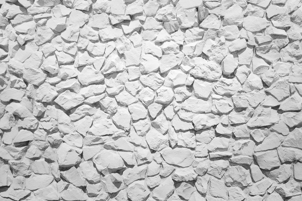 a white stone wall with small rocks on it