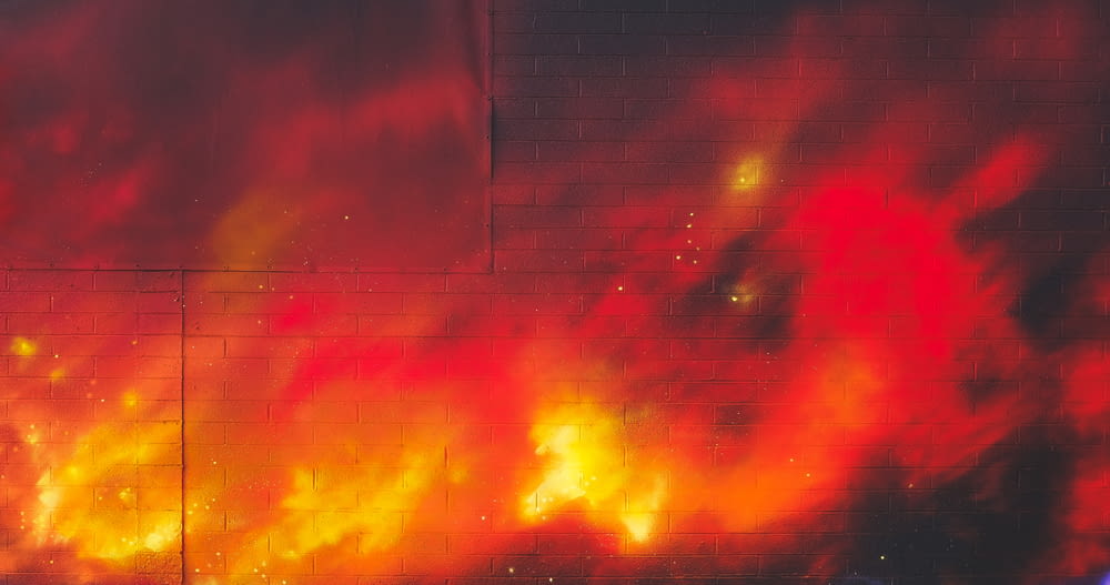 a fire hydrant in front of a wall with fire