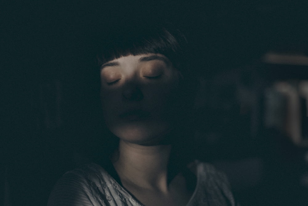 woman sitting inside dark room