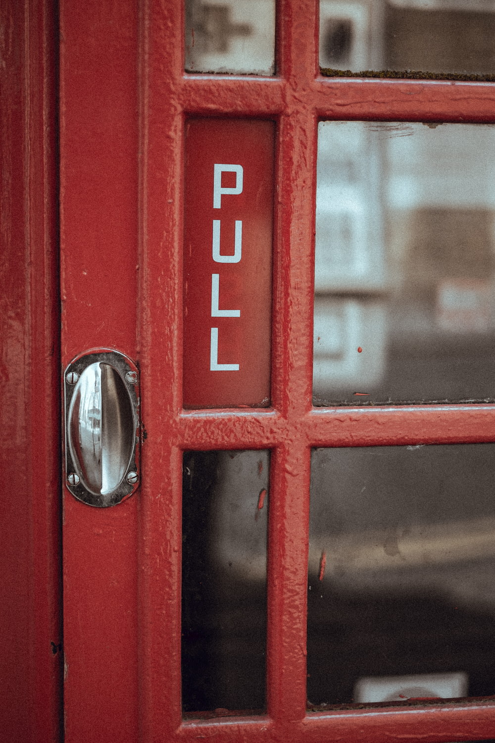 Un primer plano de una puerta roja con una manija de metal