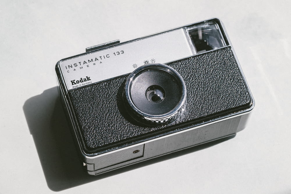 black and gray Kodak camera on white surface