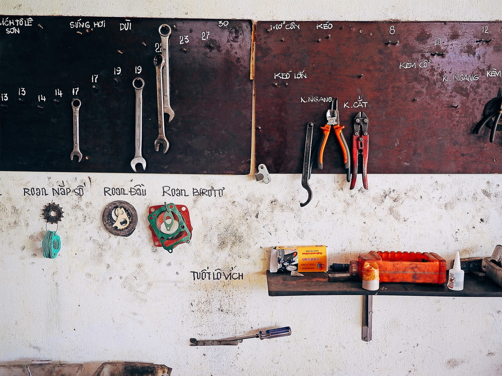 assorted steel tools on brown wall