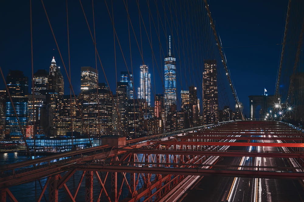 bridge near city buildings during nighttime