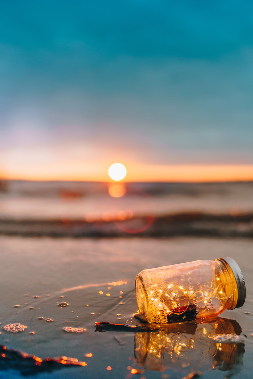 clear glass mason jar on beach during sunset