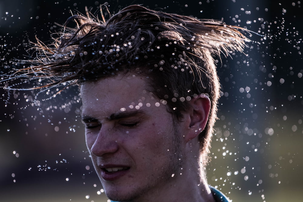 photography of man flipping hair during daytime