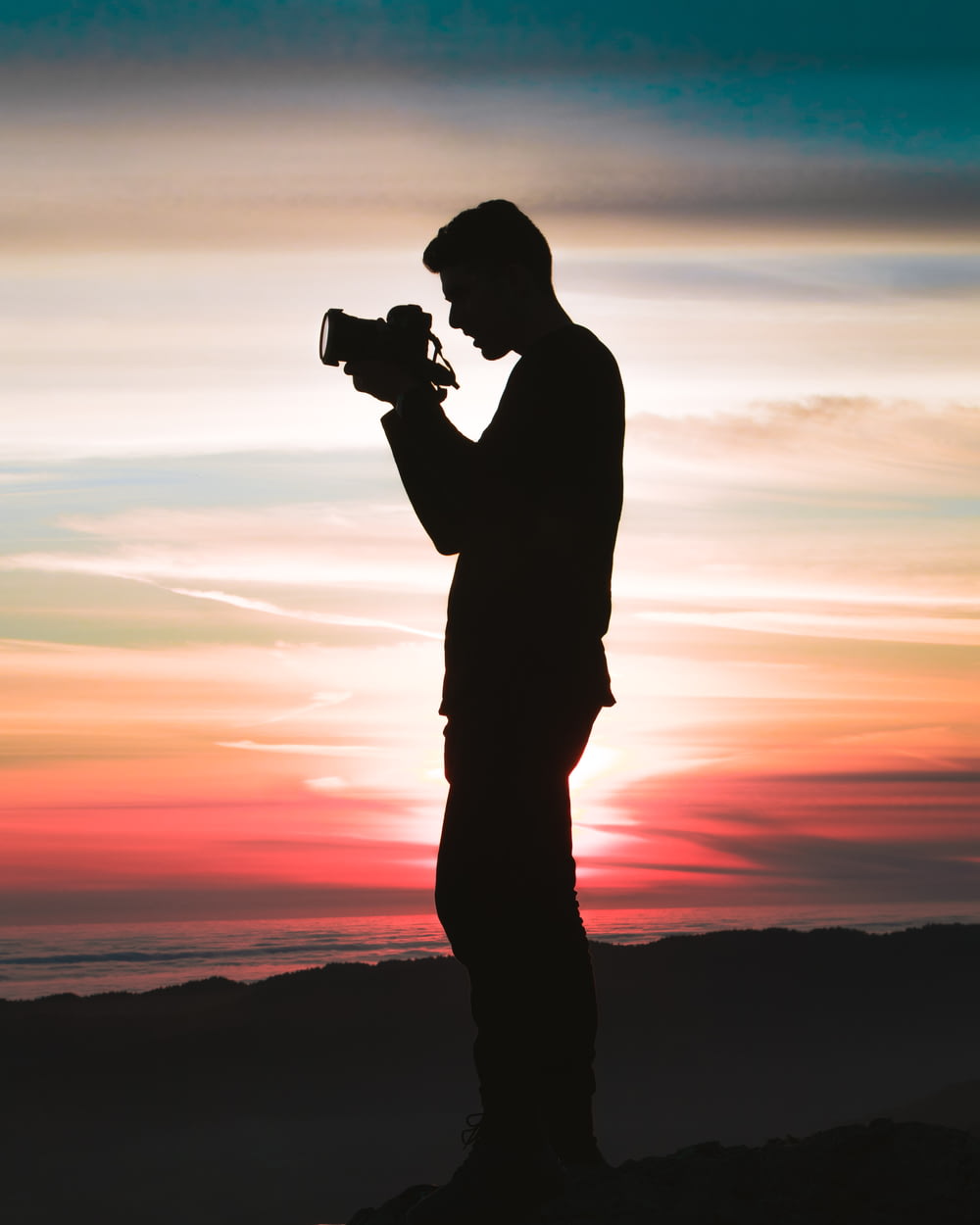 Silhouettenfoto eines Mannes, der eine Kamera hält