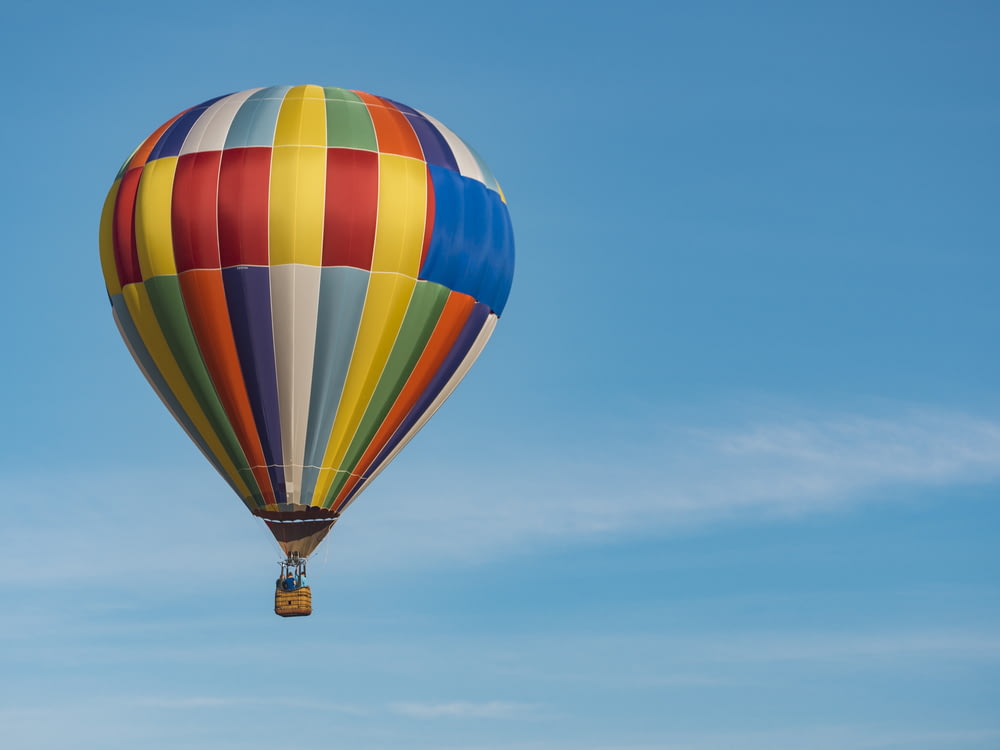 Fotografia panorâmica de balão de ar quente azul voador, amarelo e vermelho