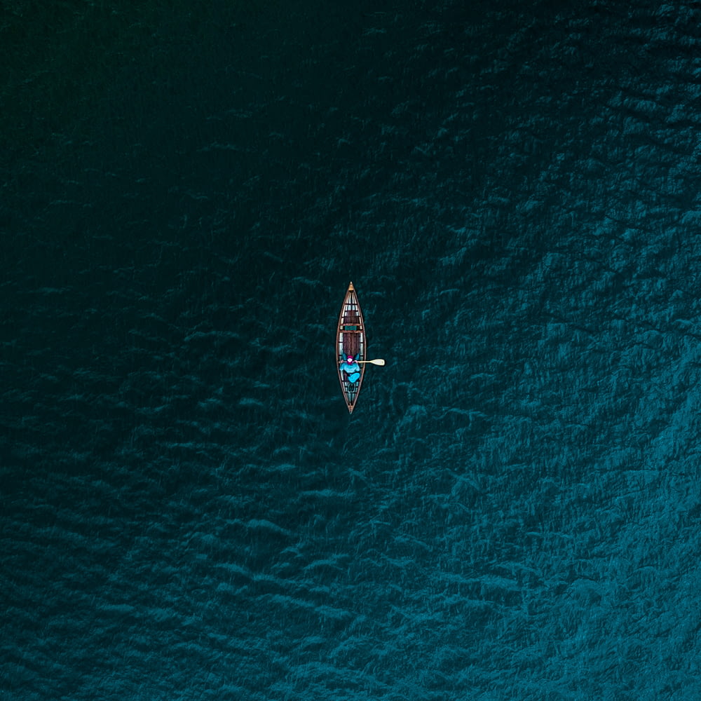 Photographie aérienne d’une personne chevauchant un bateau sur un plan d’eau