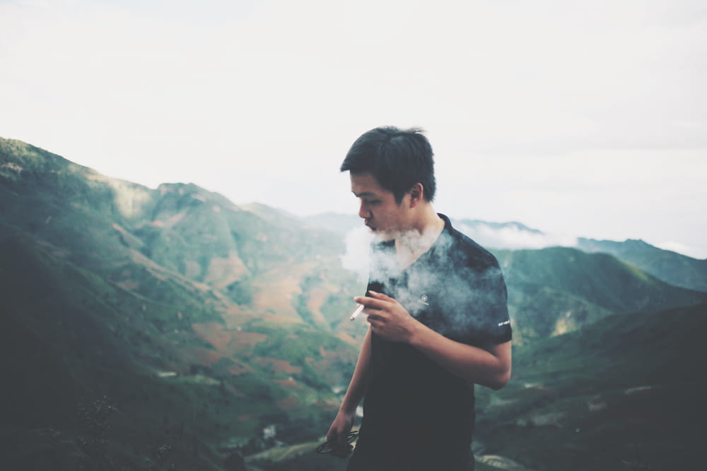 man smoking on mountain summit