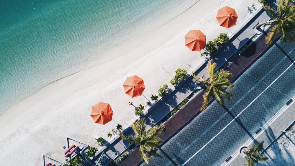 海岸近くのオレンジ色の傘の空撮