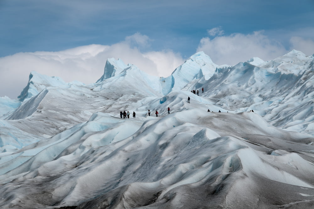 photo of people on top of snow-covered mountain