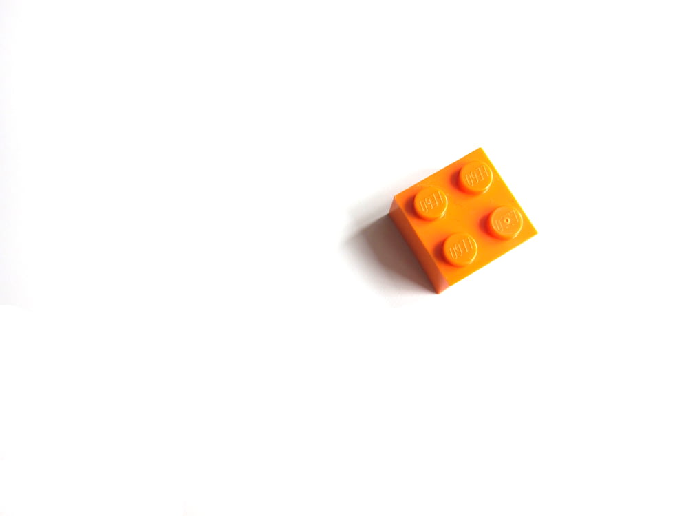 brinquedo laranja mega blocos na superfície branca
