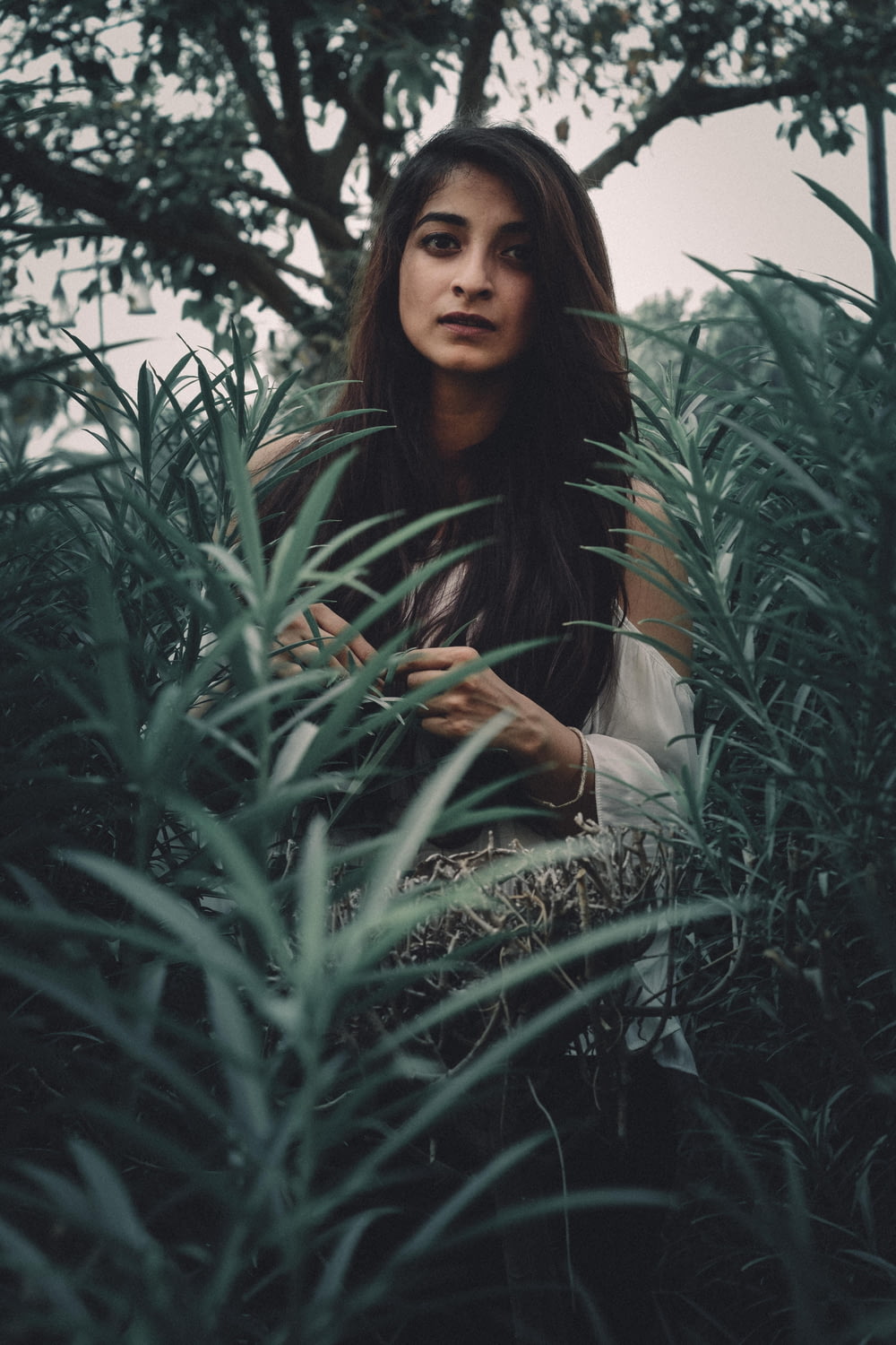 woman standing between green plants