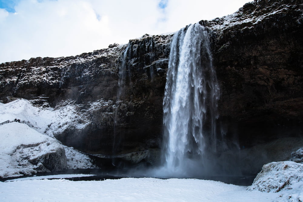 low angle photography of snow-covered waterfalls