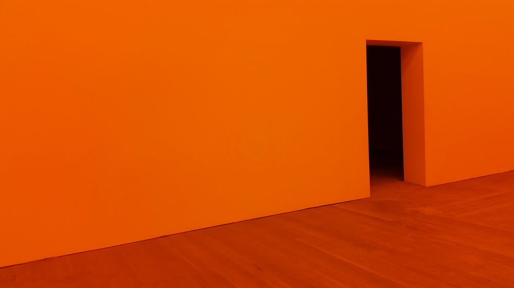 Chambre orange avec porte ouverte