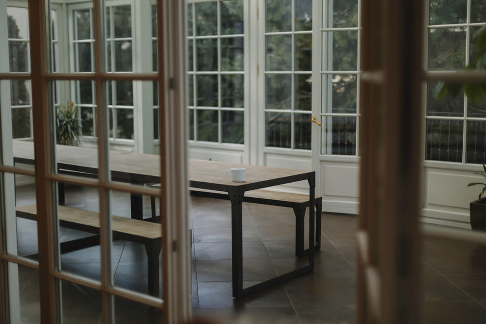 mesa de madeira marrom ao lado da parede com painéis de vidro
