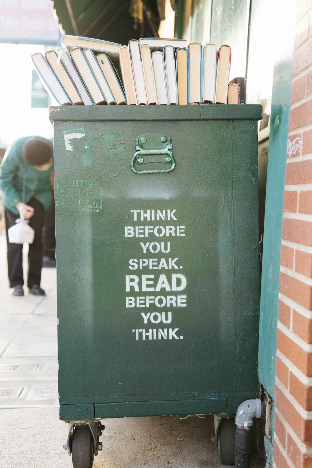 Libros sobre cubo de basura verde