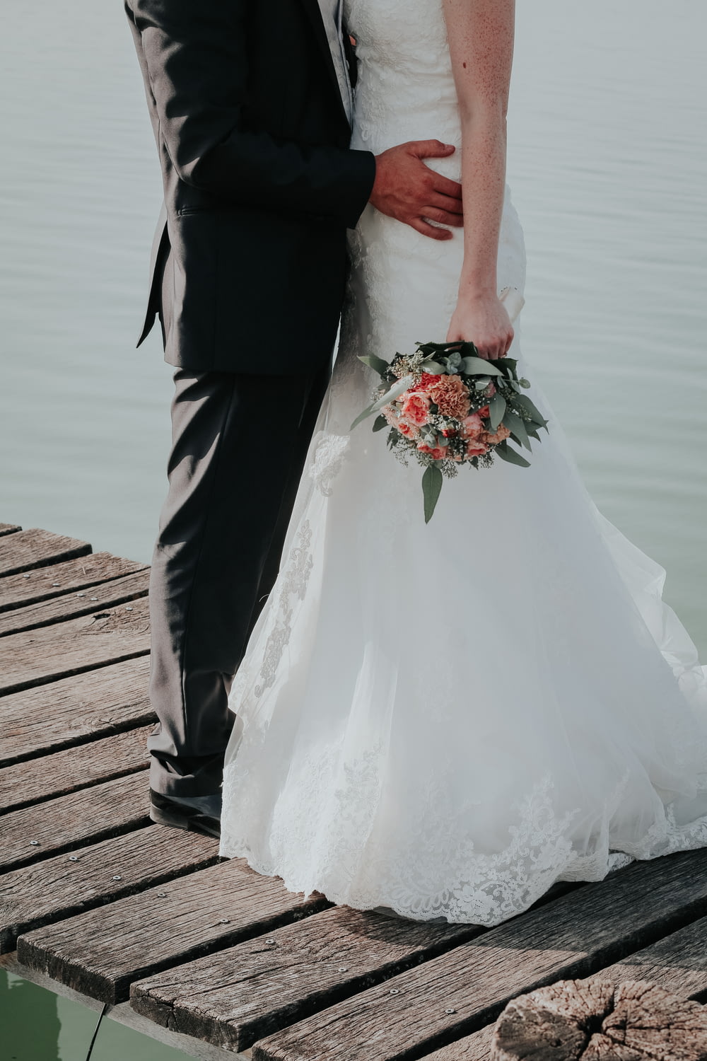 newlywed couple standing on dock