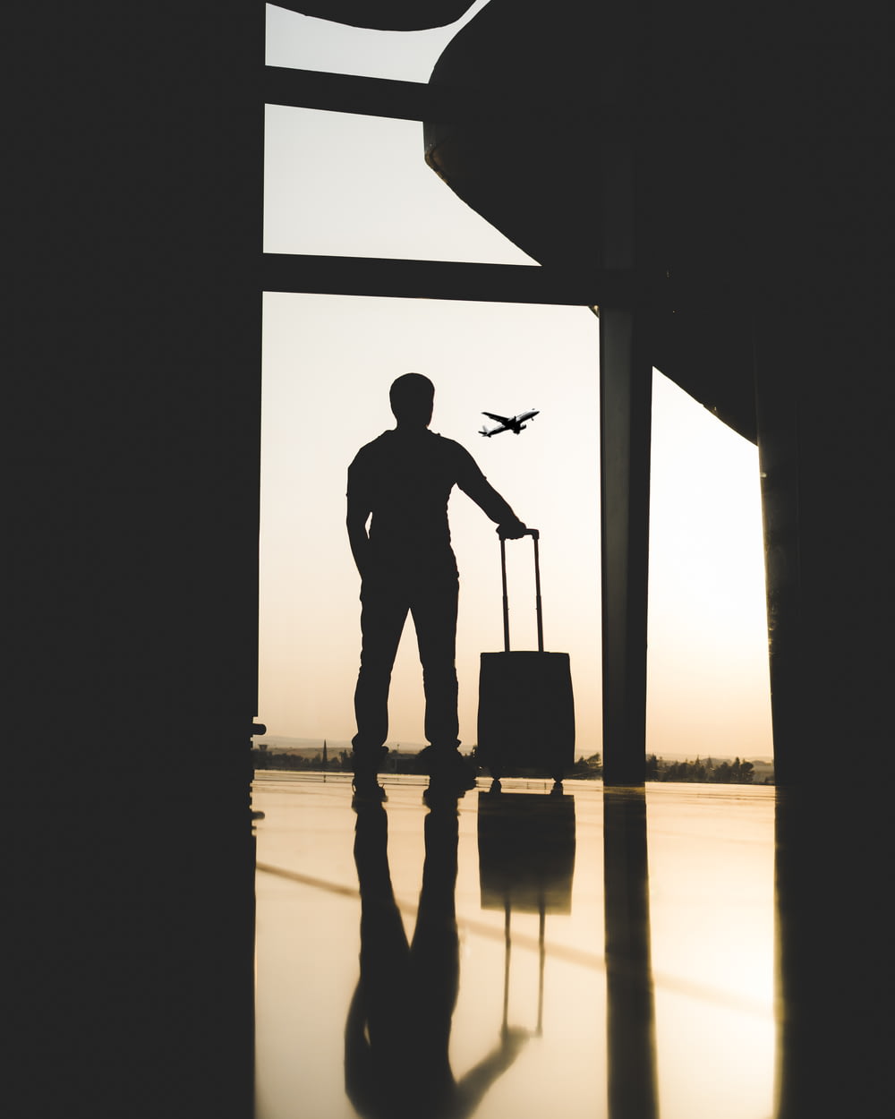 Silhouette eines Mannes, der Gepäck im Flughafen hält