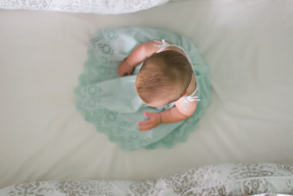 Bebé sentado en tela blanca
