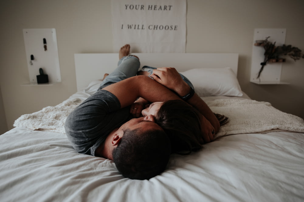 Ein Mann und eine Frau kuscheln aneinander im Bett.