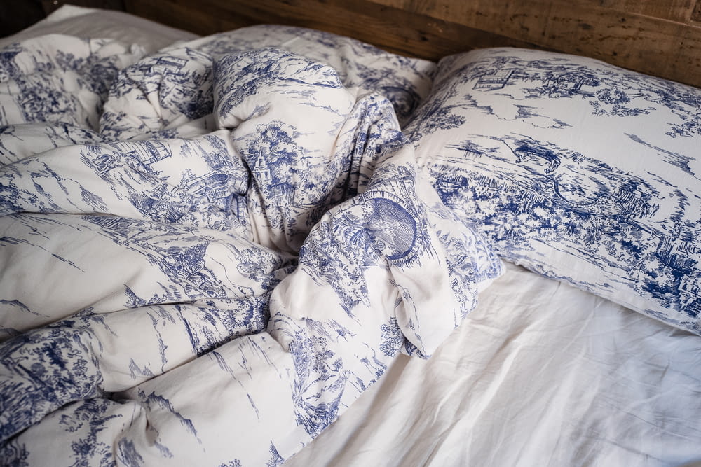 travesseiro azul e branco na cama branca