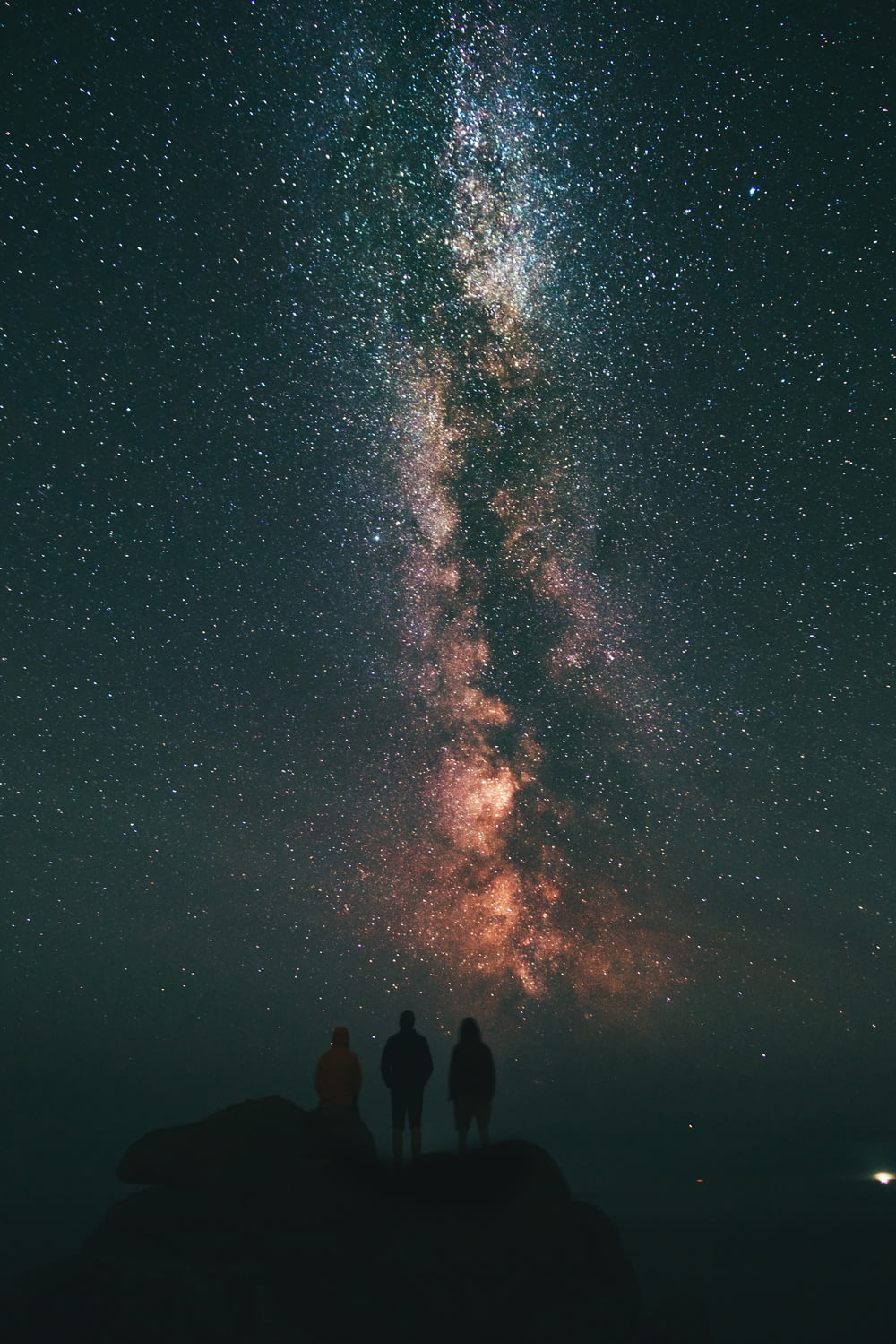 Tre persone che guardano le stelle e la Via Lattea