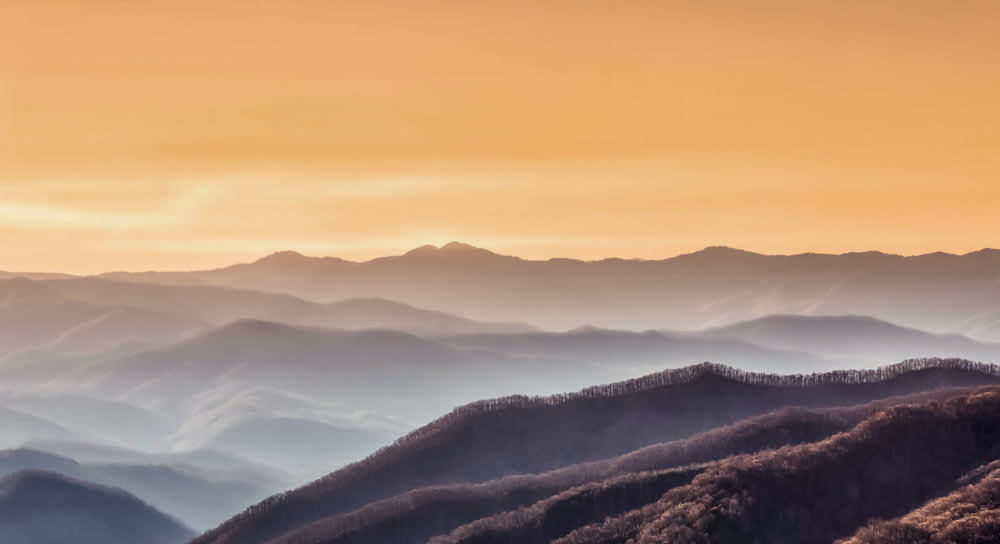 Fotografia de paisagem de montanhas durante a hora dourada