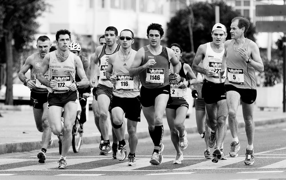 grayscale photo of people performing marathon