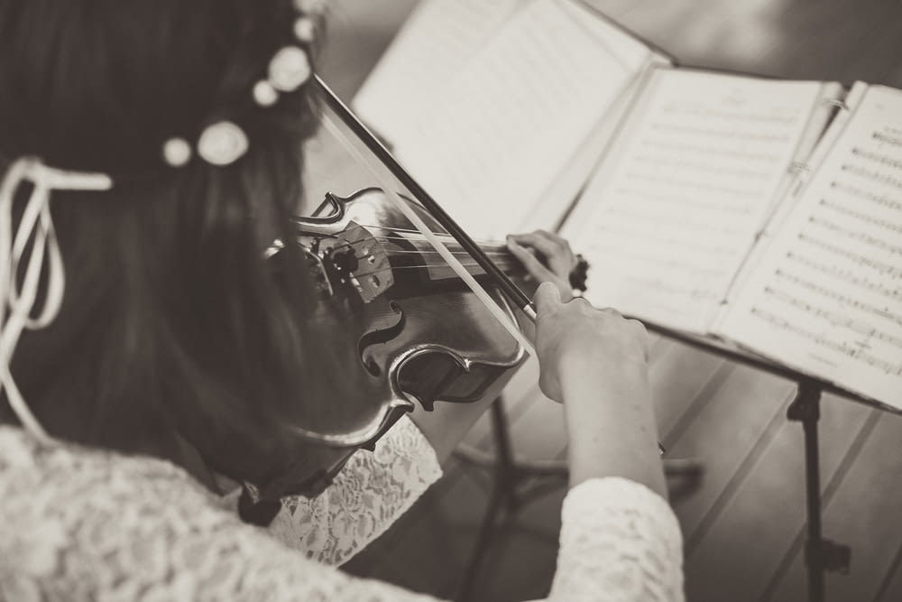 woman wearing lace top playing violin