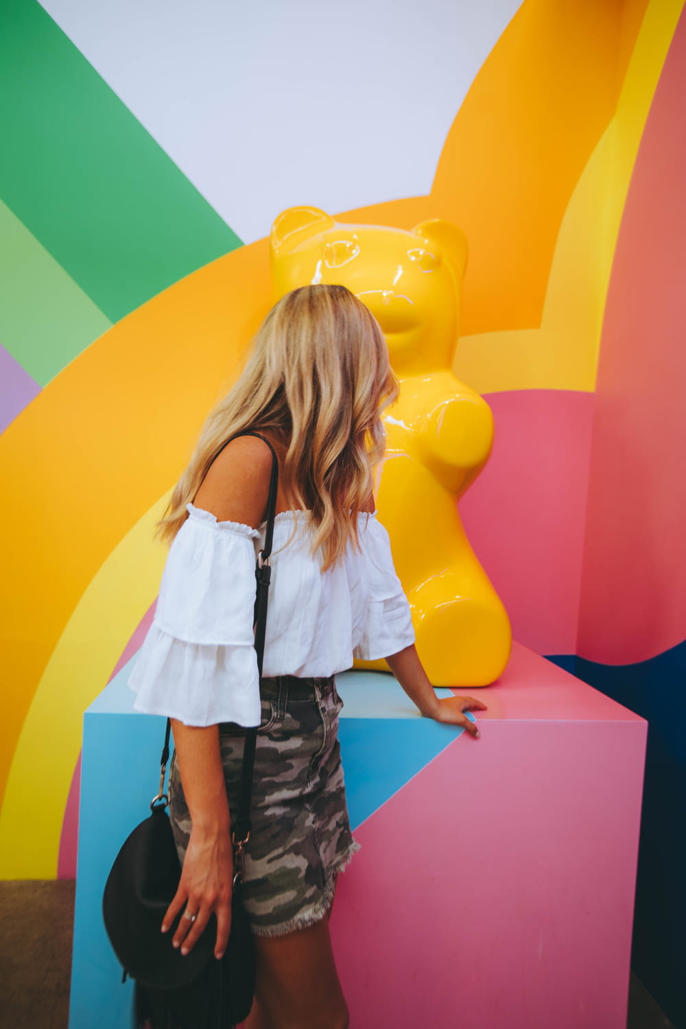 Femme regardant la sculpture d’ours jaune