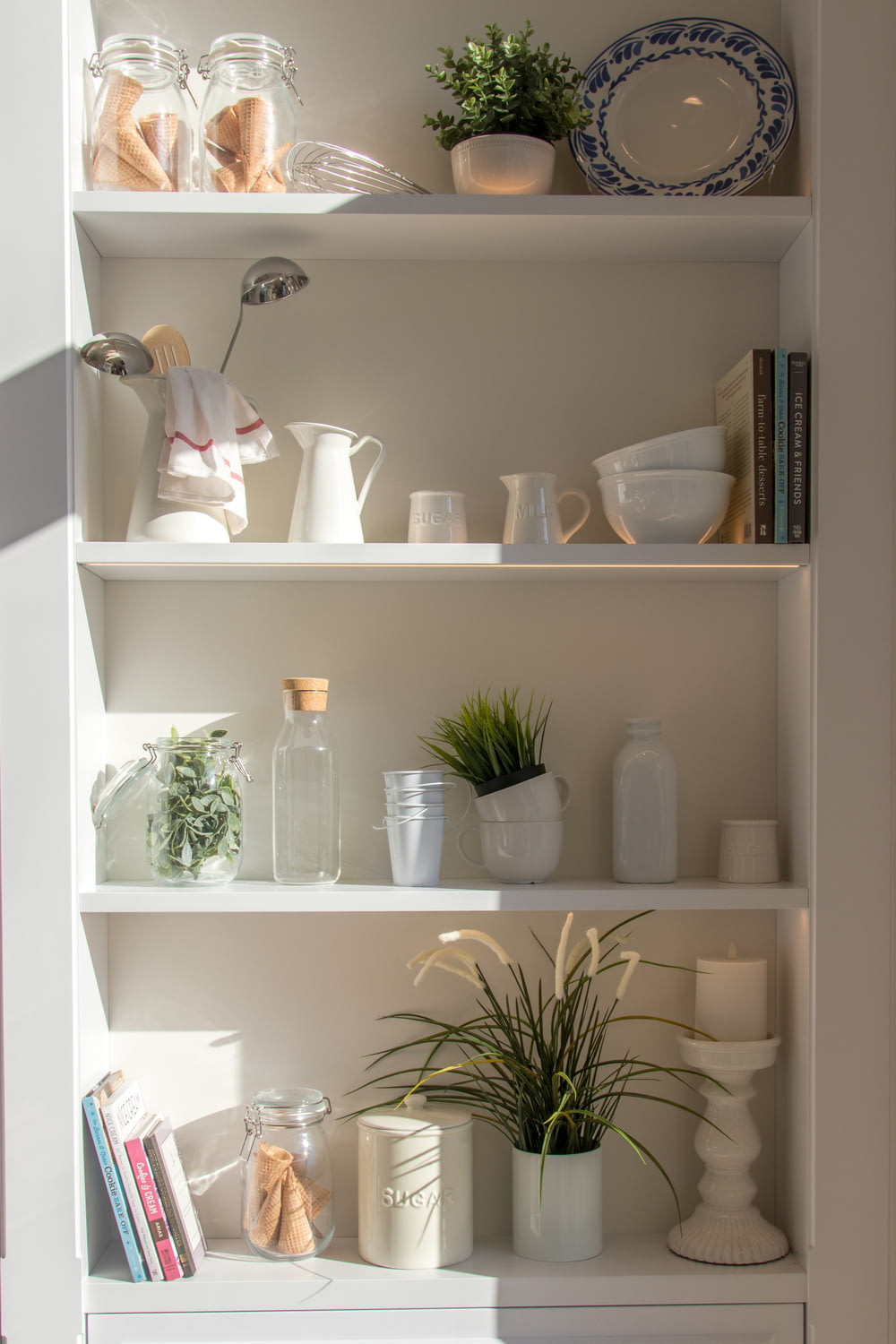 bowls and bottles in white wooden 4-layer shelf