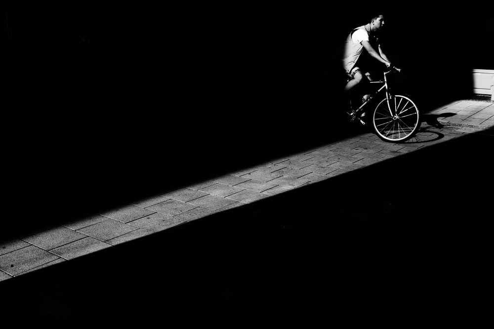 man riding bicycle in dark area