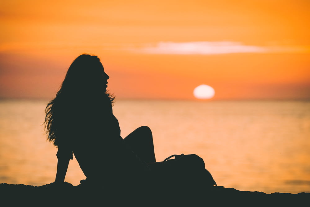 silhouette photo of woman at sunset
